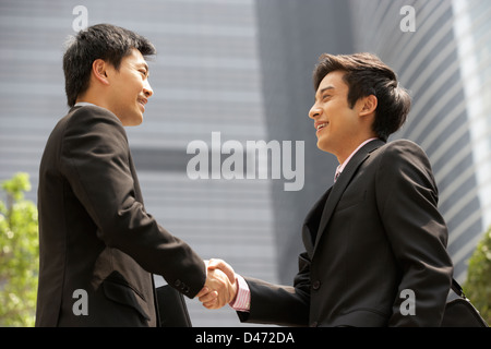 Two Businessmen Shaking Hands Outside Office Stock Photo