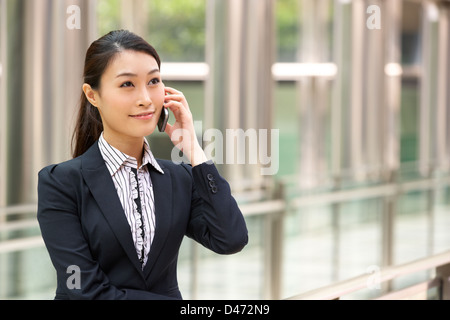Chinese Businesswoman Outside Office On Mobile Phone Stock Photo