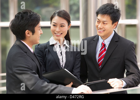 Three Business Colleagues Discussing Document Outside Office Stock Photo