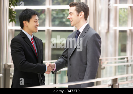 Two Businessmen Shaking Hands Outside Office Stock Photo