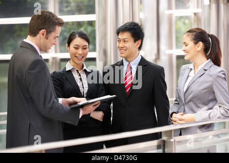 Four Business Colleagues Discussing Document Outside Office Stock Photo
