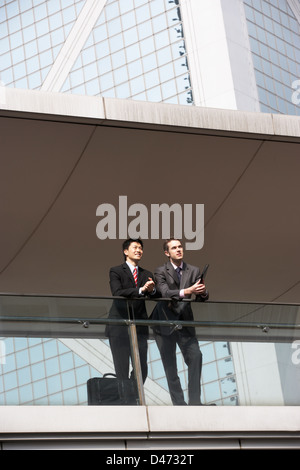 Two Business Colleagues Having Discussion Outside Office Building Stock Photo
