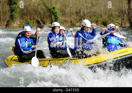 Young tourists practice rafting with a guide in Sella river in an inflatable boat in Asturias, Spain. Stock Photo