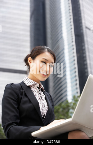 Chinese Businesswoman Working On Laptop Outside Office Stock Photo