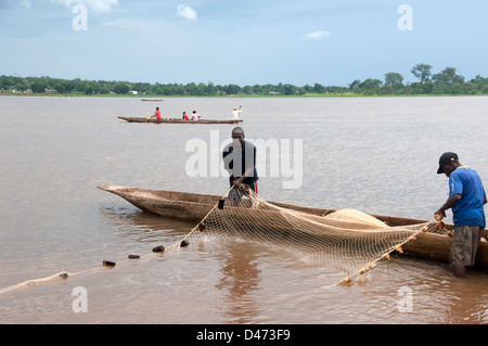 Central African Republic. August 2012. Bangui. men hauling in fishing nets to their canoe. Stock Photo