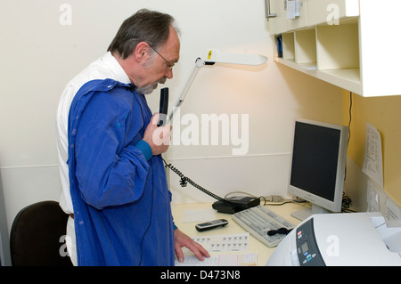 An endoscopic surgeon recording his notes after performing a procedure. Stock Photo