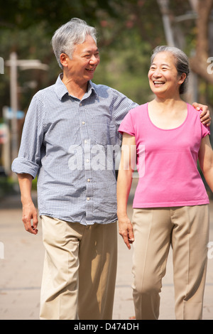 Senior Chinese Couple Walking In Park Stock Photo