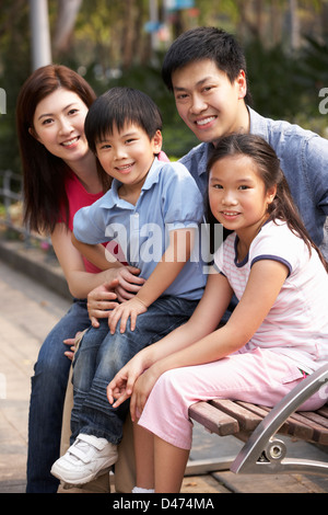 Chinese Family Walking Sitting On Bench In Park Together