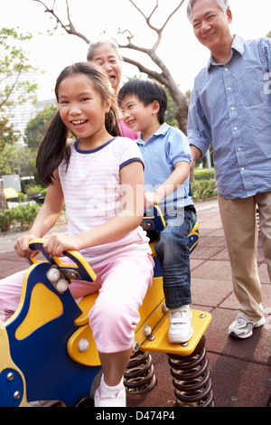 Chinese Grandparents Playing With Grandchildren In Playground Stock Photo