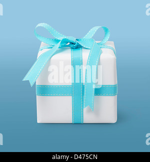 Wrapped present with turquoise ribbon cut out blue background Stock Photo