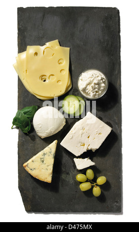 Slate cheese board with assortment of cheeses cut out on white background Stock Photo