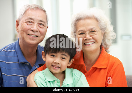 Portrait Of Chinese Grandparents With Grandson Relaxing At Home Together Stock Photo