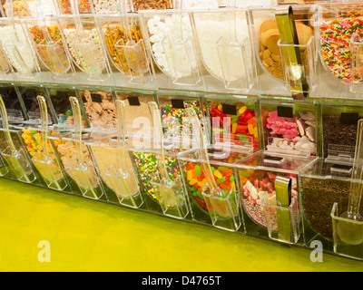 Frozen yogurt toppings bar. Yogurt toppings ranging from fresh fruits, nuts, fresh-cut candies, syrups and sprinkles. Stock Photo