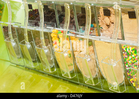 Frozen yogurt toppings bar. Yogurt toppings ranging from fresh fruits, nuts, fresh-cut candies, syrups and sprinkles. Stock Photo