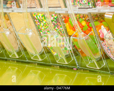 Frozen yogurt toppings bar. Yogurt toppings ranging from fresh fruits, nuts, fresh-cut candies, syrups and sprinkles. Stock Photo