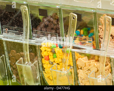 Frozen yogurt toppings bar. Yogurt toppings ranging from fresh fruits, nuts, fresh-cut candies, syrups and sprinkles. Stock Photo