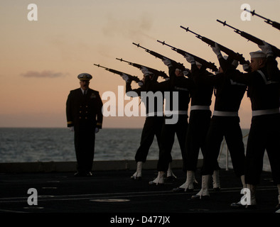 Sailors on a rifle detail fire volleys during a burial at sea for 21 former service members aboard the Nimitz-class aircraft carrier USS Carl Vinson (CVN 70) Stock Photo