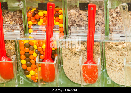 Frozen yogurt toppings bar. Yogurt toppings ranging from fresh fruits, nuts, fresh-cut candies, syrups and sprinkles. Stock Photo