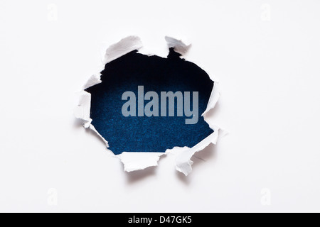 Breakthrough paper hole with black textured background. Stock Photo