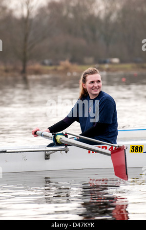 Young woman sitting relaxed in a rowing boat during a training session Stock Photo
