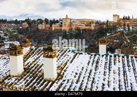 Alhambra palace with snow covered rooftops and chimneys in foreground. Granada, Spain Stock Photo