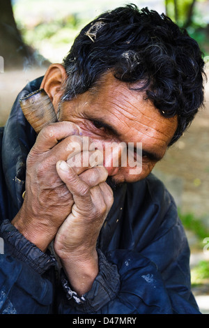 Indian man smoking on a chillum. Stock Photo