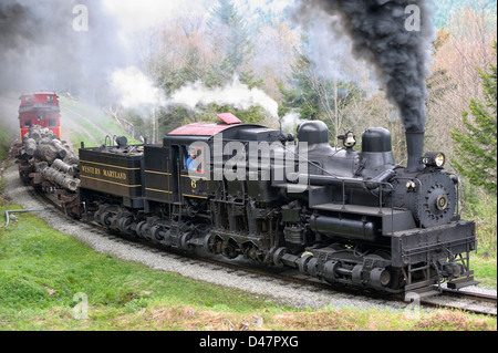 Steam engine train hauling logs rounding curve. Stock Photo