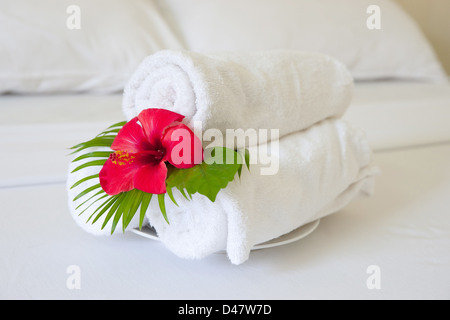 folded towels on bed in hotel room Stock Photo
