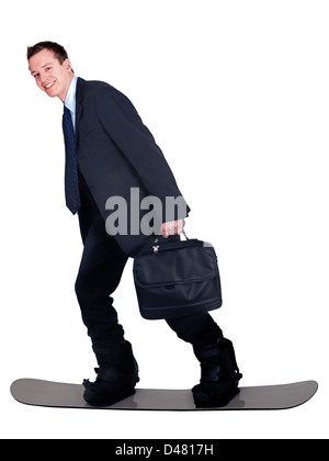 A young man in office clothes, carrying a laptop case, riding his snowboard to work. Or anyone hurring to get somewhere fast. Stock Photo