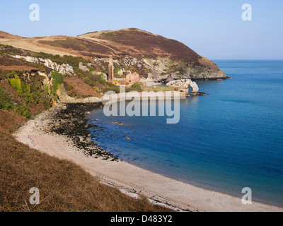 View above beach to Porth Wen derelict brickworks across clear blue sea on Isle of Anglesey coast, North Wales, UK, Britain Stock Photo