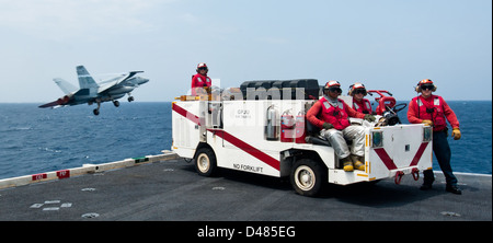 Sailors stand crash and salvage watch as two fixed-wing aircraft launch ...