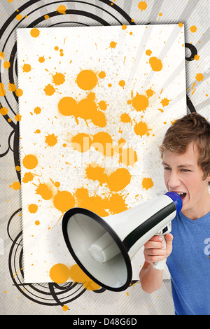 Young man shouting through megaphone in front of copy space with yellow paint splashes Stock Photo