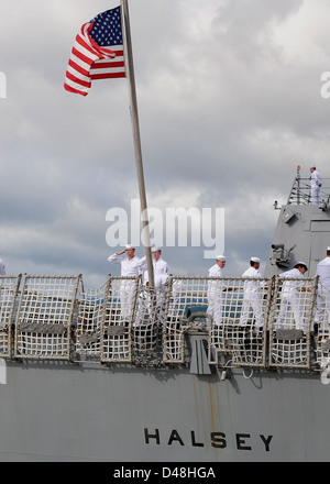 Sailors raise the American flag aboard USS Halsey. Stock Photo