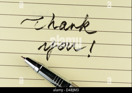 Thank you words written on lined paper with a pen on it Stock Photo