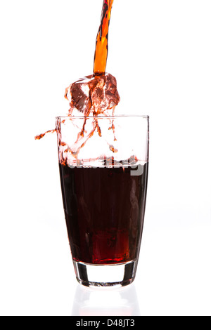 Ice cube falling in a glass being filled Stock Photo