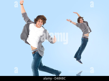 Two of the same teenage boy jumping for joy Stock Photo