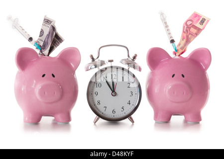 Dollar and euro notes and syringes sticking out of piggy banks with alarm clock