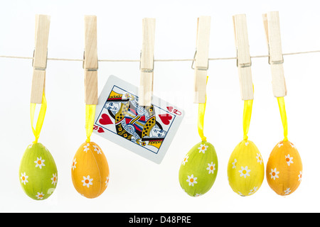 Easter eggs hanging from a line with queen of hearts Stock Photo