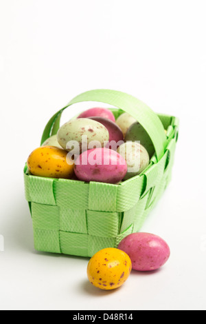 Speckled colourful easter eggs in a green wicker basket Stock Photo