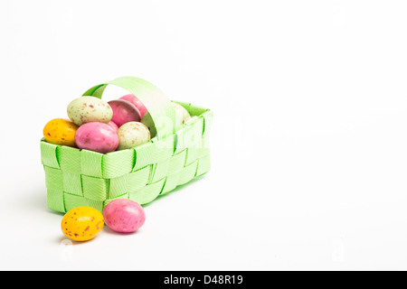 Colourful easter eggs in a green wicker basket Stock Photo