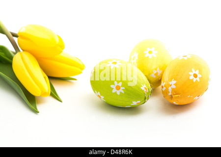 Three easter eggs with yellow tulips Stock Photo