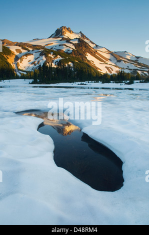 Mount Jefferson seen from ice covered Russell Lake in Jefferson Park, Mount Jefferson Wilderness, Oregon Stock Photo