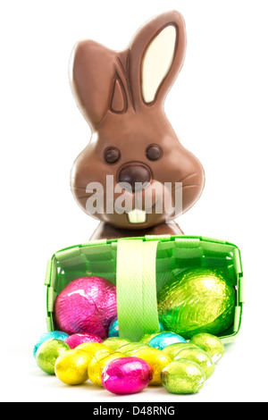 Easter eggs spilling from a basket with chocolate bunny Stock Photo