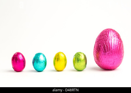 Four small easter eggs beside large one Stock Photo