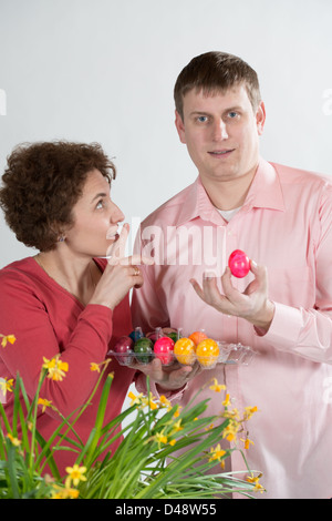 young parents hiding easter eggs Stock Photo - Alamy