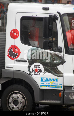 Bournemouth, UK. 8th March 2013. COMEDY Darren the dinosaur is released onto the streets of Bournemouth in aid of Comic Relief. Darren the dinosaur is three metres tall by eight metres long and was used in Walking with Dinosaurs, He was set free by celebrity Chris Jarvis from outside the BIC. The event was organised by Sainsbury's to encourage people to call into any store to get their red noses to protect themselves should they see the prehistoric creature while out and about. Credit:  Carolyn Jenkins / Alamy Live News Stock Photo