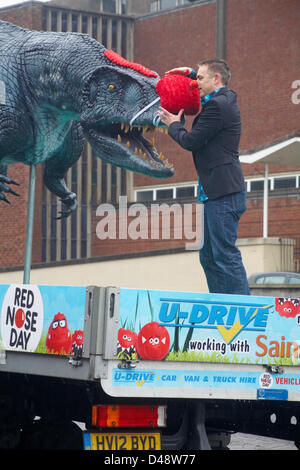 Bournemouth, UK. 8th March 2013. COMEDY Darren the dinosaur is released onto the streets of Bournemouth in aid of Comic Relief. Darren the dinosaur is three metres tall by eight metres long and was used in Walking with Dinosaurs, He was set free by celebrity Chris Jarvis from outside the BIC. The event was organised by Sainsbury's to encourage people to call into any store to get their red noses to protect themselves should they see the prehistoric creature while out and about. Credit:  Carolyn Jenkins / Alamy Live News Stock Photo