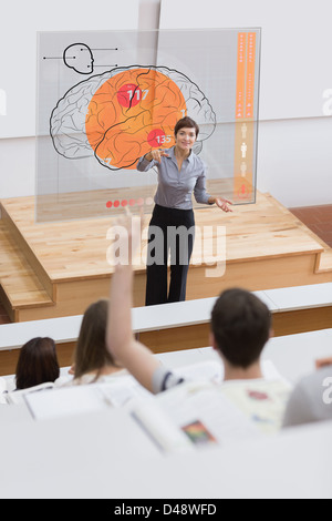 Teacher in front of futuristic interface pointing student Stock Photo