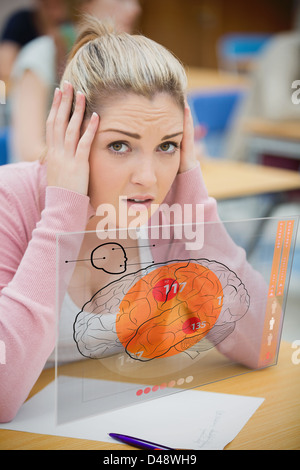Blonde woman thinking hard while studying on futuristic interface