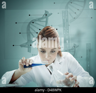 Blonde scientist working with futuristic interface and  pouring liquid into erlenmeyer Stock Photo